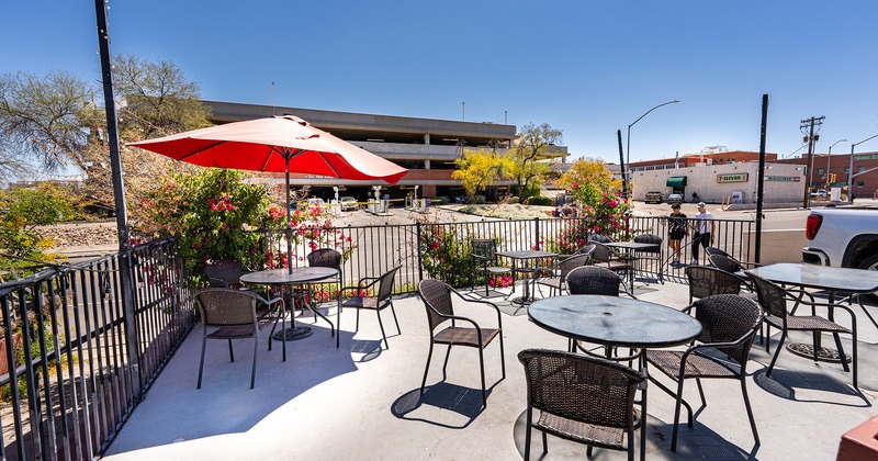 Outdoor seating area, tables, chairs, red parasol