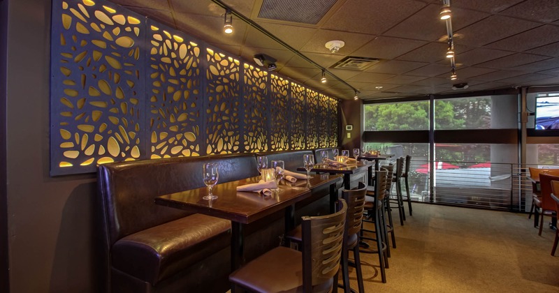 Upstairs, banquette seating with tables and chairs, decorative screen wall