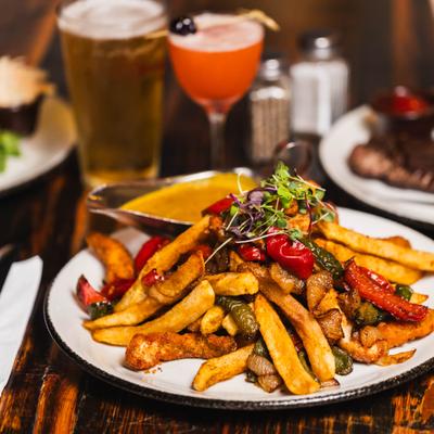 Curry fries with chicken, roasted red peppers, and microgreens.