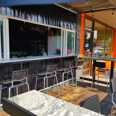 Exterior, seating area, pass through window with a counter and chairs.