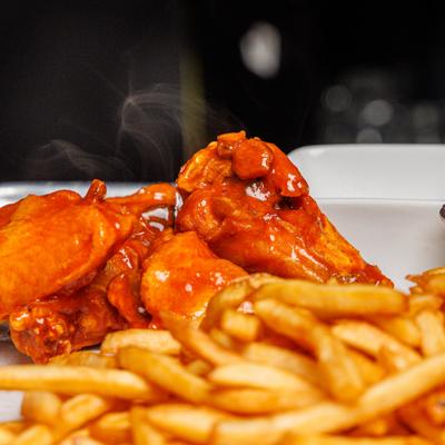 Buffalo Wings served with a side of fries.
