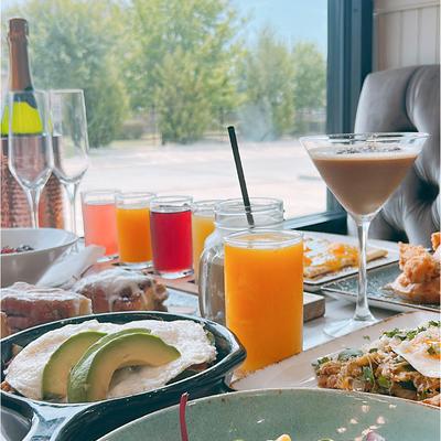 Assortment of food dishes and drinks displayed on a table inside.