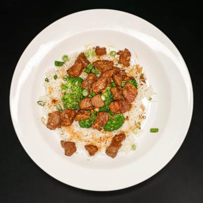 Steak chunks and broccoli on a bed of rice.
