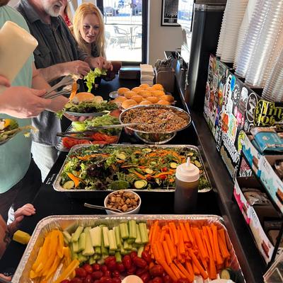 People helping themselves to food on buffet trays.