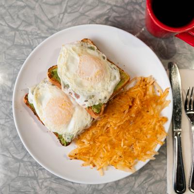 An avocado toast with hashbrowns.