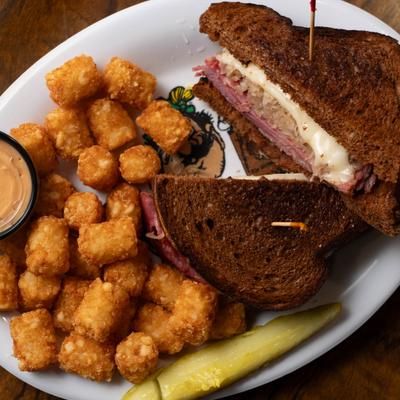 Bierstube's Signature Reuben Sandwich served with tater tots and dipping sauce.