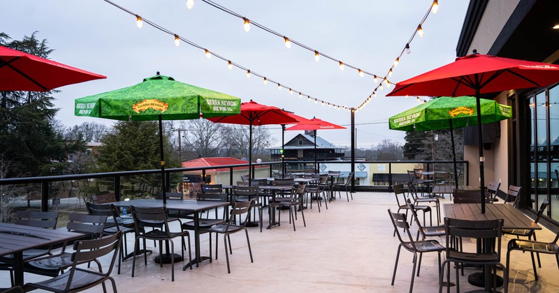 Exterior, terrace, glass and metal railing, tables and chairs with parasols