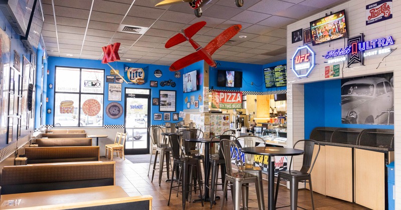 A restaurant interior featuring blue walls and a stylish bar area