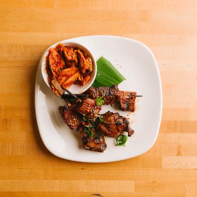 Kochujang beef skewers served with kimchi.