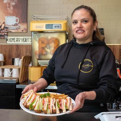 Employee holding a plate with Club House sandwich