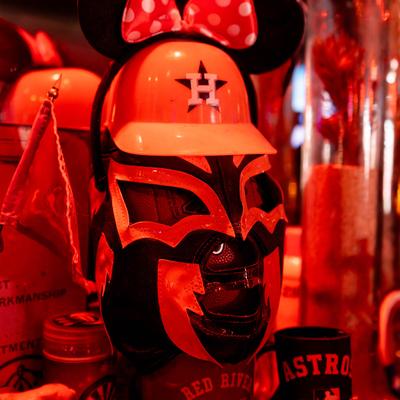 A decorative mask with a helmet and Minnie Mouse ears on a wall.