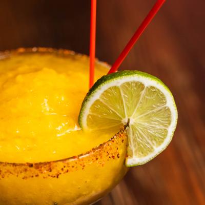 Frozen cocktail served in a rimmed coupe, garnished with a lime wheel.