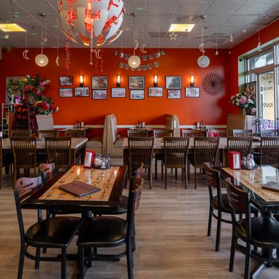 Restaurant interior with tables, chairs, hanging ligts and decorations.
