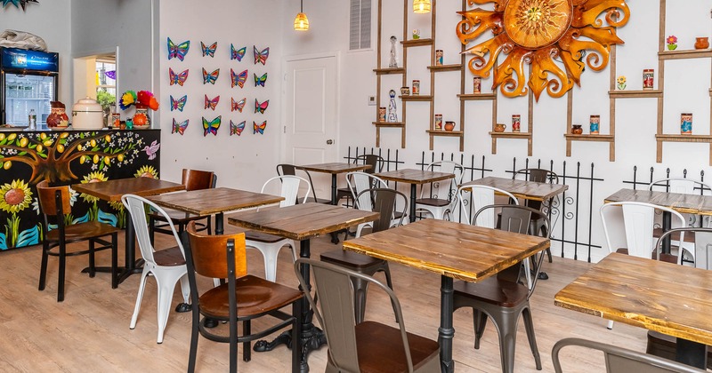 Interior, tables and chairs with decorated wall in the back