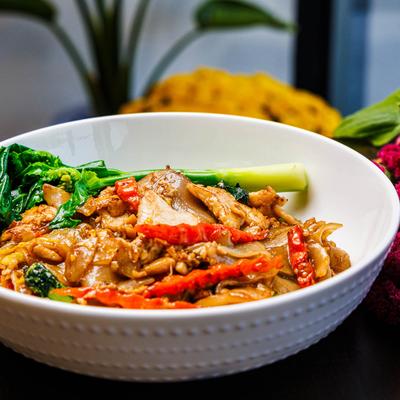 Flat rice noodles with black sweet soy sauce, egg, carrots, and Chinese broccoli.