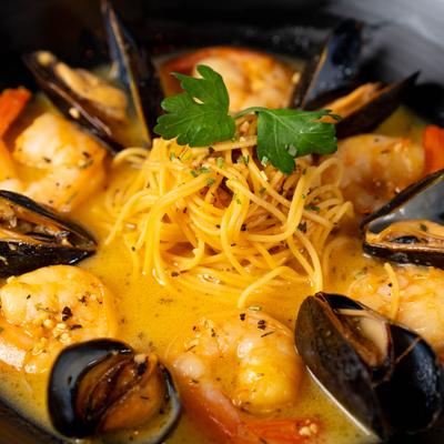 Shrimp and mussels with pasta noodles in creamy broth