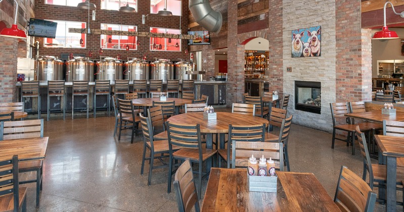 Interior, seating area, round wooden top tables for eight, beer tanks in the back