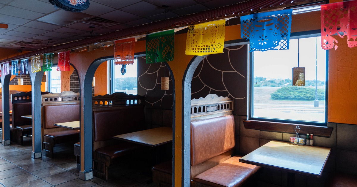 Restaurant interior with booths and colorful paper picado banners