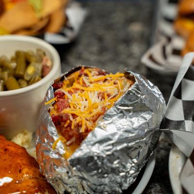 A loaded baked potato served as a side dish.