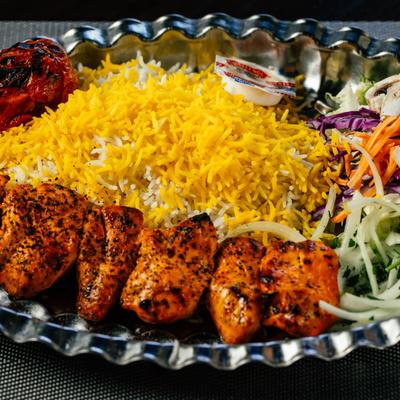 Grilled chicken skewers, rice, and salad.