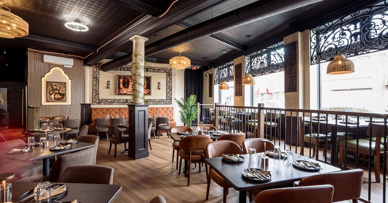 Interior of modern and spacious dining area with dining tables set for guests