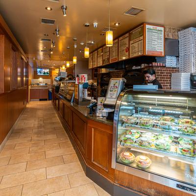 Interior of Louie’s Pizzeria with counter service and salad display.