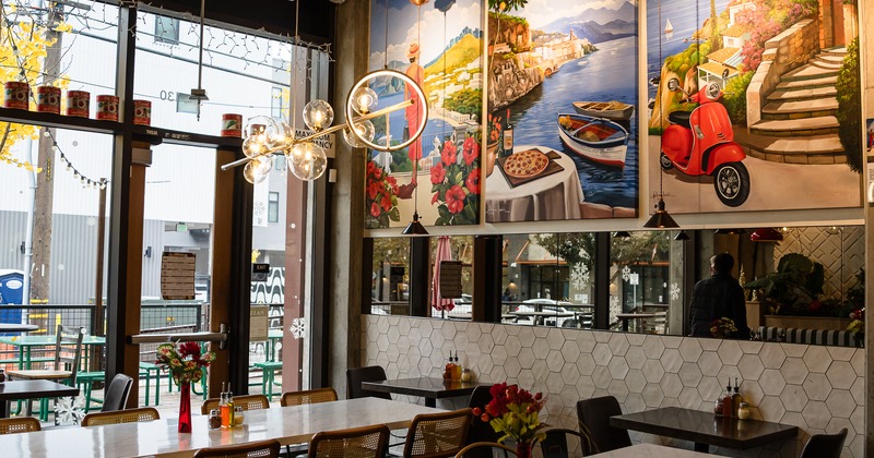 Interior, diner tables, chairs, decorated wall, storefront facing the street