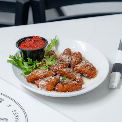 Fried Cheese Wedges served on a bed of lettuce with marinara sauce.