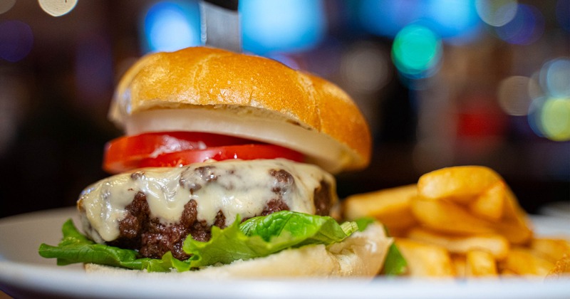 The classic burger and french fries on a white plate, close up