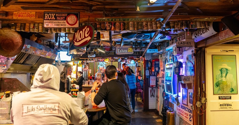 Bar interior, guests sitting at the bar counter, bar staff