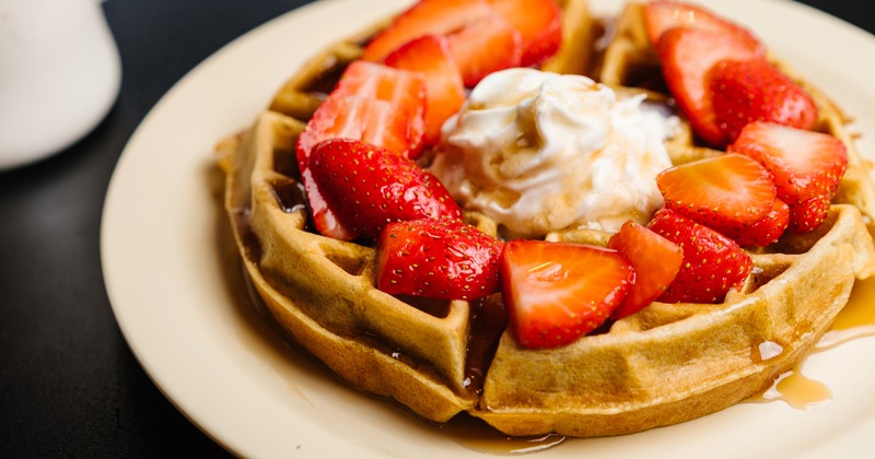Waffle topped with whipped cream and strawberries