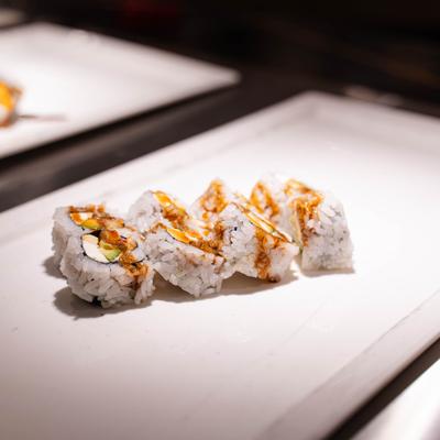 Uramaki sushi rolls drizzled with sauce.