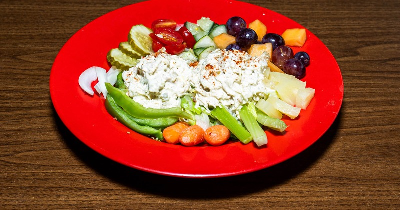 Fresh vegetables and fruits topped with chicken salad