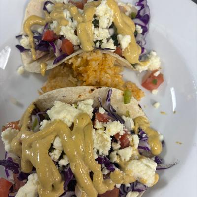Street tacos topped with red cabbage, feta, fresh salsa, and aioli.
