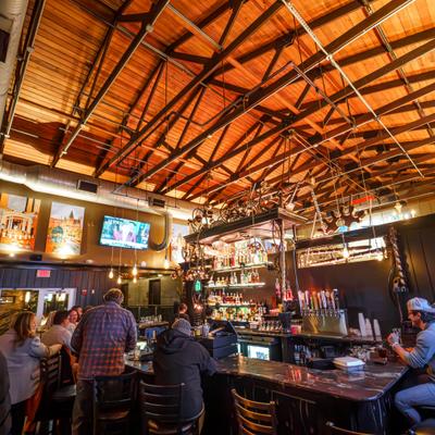 Restaurant bar with high ceilings and seated guests.