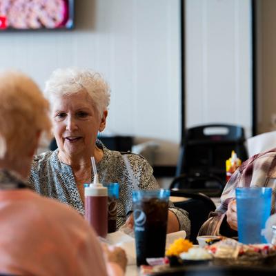 Guests dining together at a table with food, drinks, and condiments.