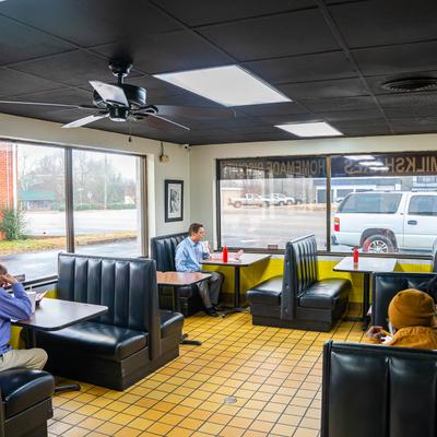 Interior, guests sitting in booths by the windows