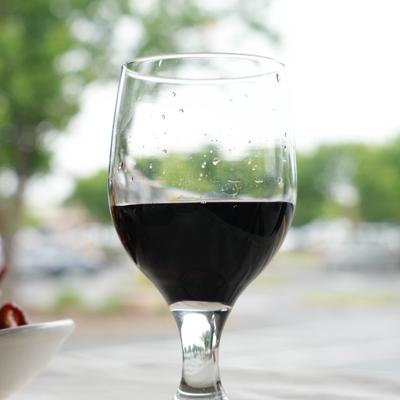 Glass of red wine served on a outdoor table.