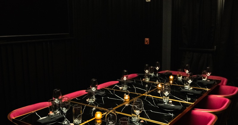 Private dining table with place settings and red chairs