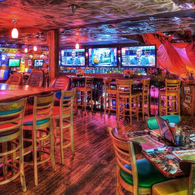 A vibrant bar interior with colorful lightin