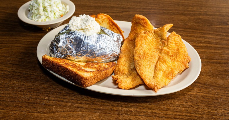 Fried flounder served with a baked potato and toasted bread