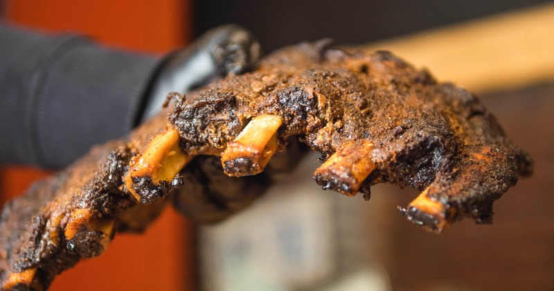 Staff holding a piece of bison back ribs