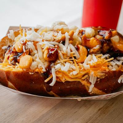 Big cheese dawg topped with sauces and grated cheeses.