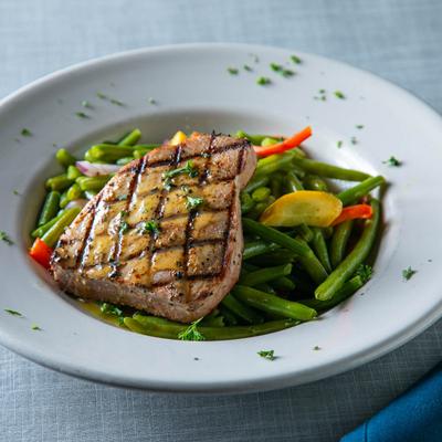 Grilled Tuna Steak served over cooked vegetable blend.