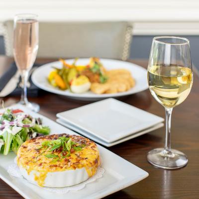 Southern Tomato Pie accompanied with white wine on a dining table