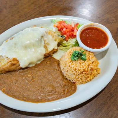 Chile relleno with melted cheese, refried beans, rice, lettuce, tomatoes, and red salsa.