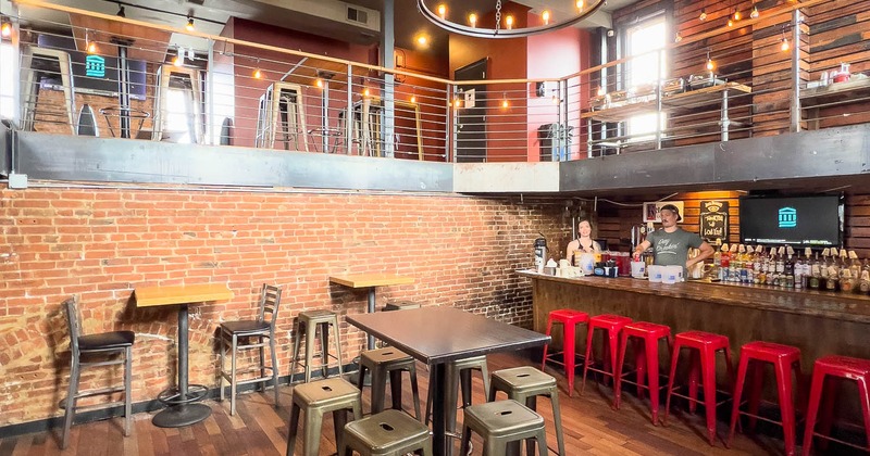 Interior,  high tables and bar stools below terrace near bar