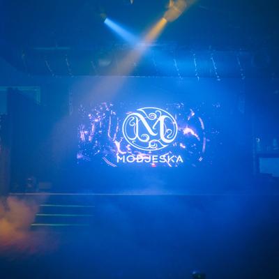 Stage with illuminated sign and blue and yellow lighting effects.