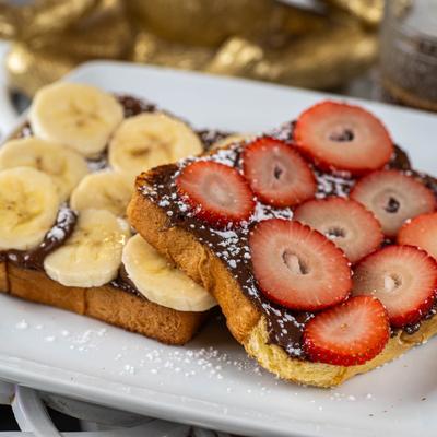 Two slices of bread with hazelnut spread with powdered sugar, strawberry and banana.