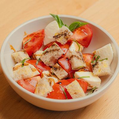 Tomato salad with toasted bread, fresh basil, mozzarella, balsamic, and olive oil.